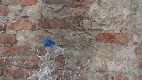 Ein-Blauer-Wasserballon-Aus-Gummi-Wird-Gegen-Eine-Mauer-Geworfen-Und-Platzt