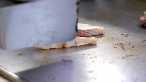 Marmorforellenfisch-Auf-Einem-Grill-Und-Wenden-Mit-Einem-Pfannenwender,-Nahaufnahme