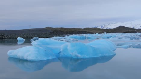A-beautiful,-bluish-white-iceberg-floating-in-a-lake-in-Iceland---wide-shot