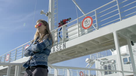 A-Woman-in-Sunglasses-Walks-Along-the-Deck-of-a-Ferry-on-a-Bright-Sunny-Day,-Low-Angle