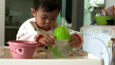 Medium-shot-of-cute-Asian-baby-girl-drinking-water-from-bottle