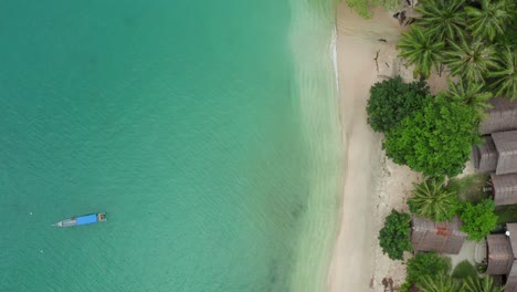 Aerial-top-down-shot-with-no-motion-of-turquoise-lagoon-waves-on-village-beach
