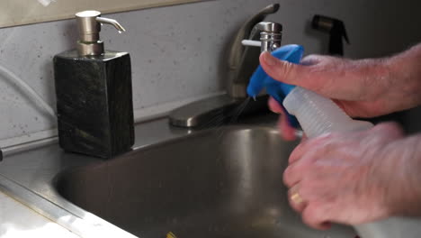 Man-Hands-Cleaning-Surfaces-By-Spraying-Alchohol-And-Rubbing-Towel---Closeup-Shot