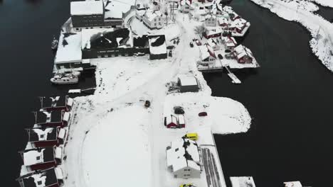 Rote-Häuser-Und-Boote-Am-Hafen-In-Einer-Verschneiten-Landschaft-Mit-Den-Bergen-Im-Hintergrund-Während-Der-Winterzeit-In-Norwegen