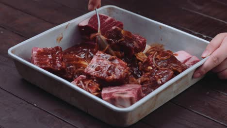 Marinating-raw-meat-ribs-with-sauce-in-a-baking-pan