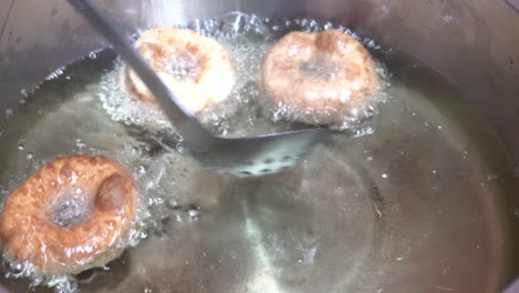 Donuts-frying-in-oil-in-a-kettle-on-the-stove
