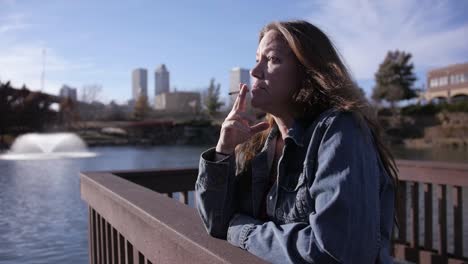 Tired,-homeless-woman-taking-a-drag-on-her-cigarette-in-wide-angle