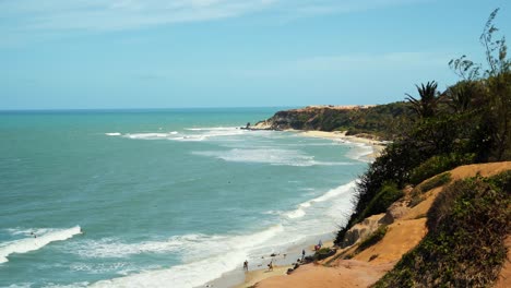 Beautiful-tilt-up-to-the-exotic-tropical-beach-of-Praia-do-Amor-near-Pipa,-Brazil-on-a-warm-summer-day