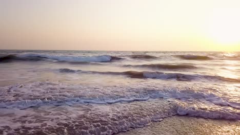 Close-aerial-of-waves-on-a-beach-during-sunset