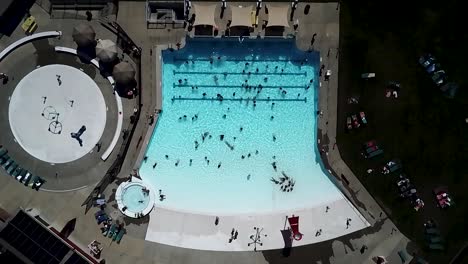 Slow-ascending-aerial-shot---People-Having-Fun-At-The-Turquoise-Blue-Water-In-The-Wave-Pool-At-Kandle-Park-In-Tacoma,-Washington-On-A-Summer-Day