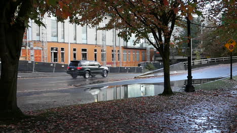 Slow-Motion-of-cars-driving-through-a-puddle-of-water-in-Portland,-Oregon-USA-in-high-resolution-HD