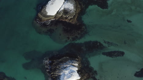 Aerial-View-of-Snow-Covered-Islands-in-a-Colorful-Shallow-Coastline