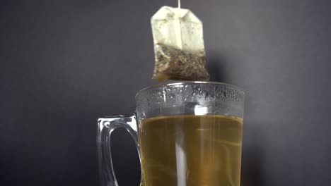Hot-steaming-tea-is-prepared-and-brewed-in-a-glass-against-a-dark-background