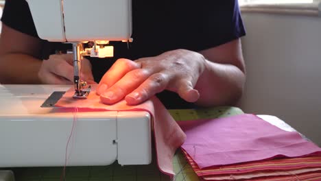 Close-up-view-of-woman’s-hands-sewing-fabric-squares-on-sewing-machine