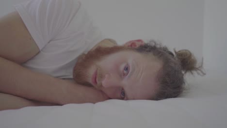 Sad-man-lying-on-a-bed