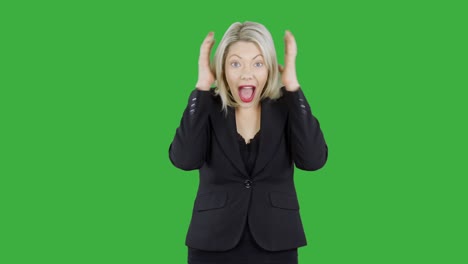 Attractive-blonde-woman-in-front-of-chroma-key-green-screen-is-happy-surprised-and-shocked