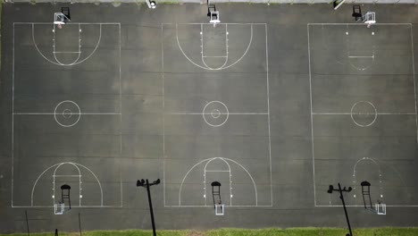 Empty-Laie-Park-basketball-courts-with-shadows,-Hawaii,-aerial-birds-eye-view