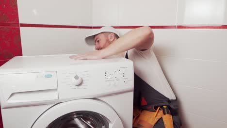 the-plumber-in-working-form-shows-that-the-washing-machine-has-failed-and-cannot-be-repaired
