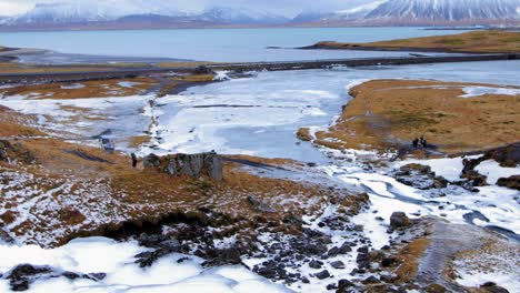 Hermoso-Paisaje-De-Lago-Congelado-Y-Montaña-Cubierta-De-Nieve-En-La-Distancia,-Islandia-Durante-El-Invierno