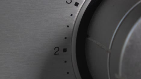 Volume-dial-knob-on-vintage-stereo-being-turned-down-with-numbers-shown-on-side