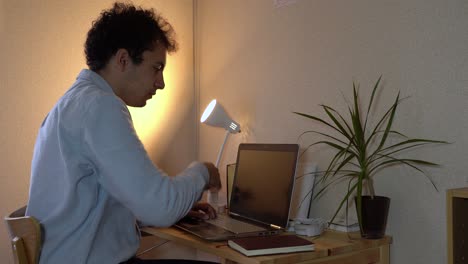 A-Man-Working-On-His-Laptop-At-Home-Office-Sneezes-In-His-Arm-To-Prevent-Spreading-Of-Coronavirus---Closeup-Shot