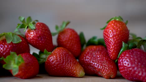 Köstliche,-Selbst-Angebaute,-Wunderschöne-Rote-Erdbeeren,-Die-Auf-Einer-Hölzernen-Arbeitsplatte-Sitzen,-Pfanne-Rechts