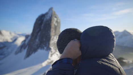 Ein-Mann-Setzt-Einen-Schneehut-Mit-Dem-Ikonischen-Berg-Segla-Von-Norwegen-Im-Hintergrund-Auf