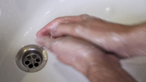 Eine-Person,-Die-Sich-Die-Hände-Richtig-Wäscht,-Indem-Sie-Die-Weiße-Seife-Zwischen-Ihren-Händen-Reibt