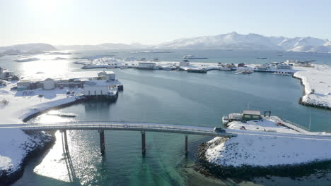 Aerial-View-Of-Beautiful-Arctic-Winter-Scenery-With-Car-Passing-Bridge-in-Sommarøy,-Norway