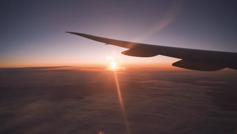 Airplane-window-view.-Sun-setting-on-horizon