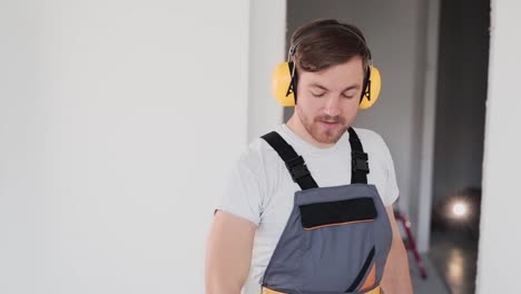 repairman-puts-on-headphones-and-takes-a-drill-in-his-hand