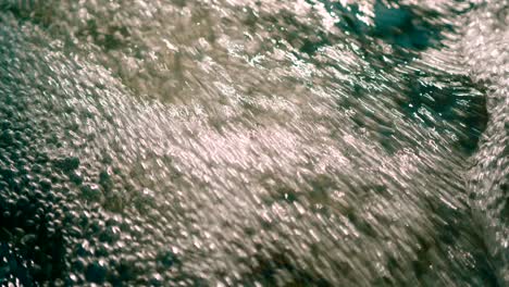 Closeup-view-of-fresh-water-stream-gushing-air-bubbles-popping