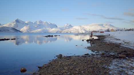 Ein-Mann,-Der-Von-Einer-Felsigen-Küste-Entlang-Eines-Fjords-In-Norwegen-Aus-Einen-Blick-Auf-Die-Erstaunliche-Winterlandschaft-Genießt,-Statisch