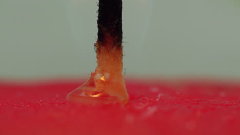 Time-lapse:-macro-studio-view-of-yellow-candle-wax-bubbling-and-melting-down-into-red-wax