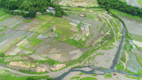 Aerial-Shot-Of-Various-Farm-Lots-In-Different-Sizes-Beside-A-River