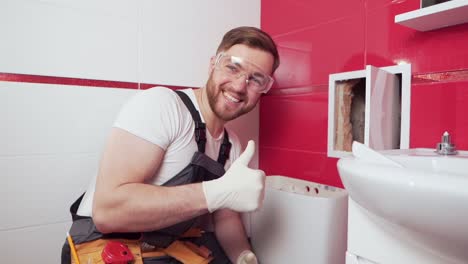 A-professional-plumber-in-the-toilet-shows-his-thumb-up