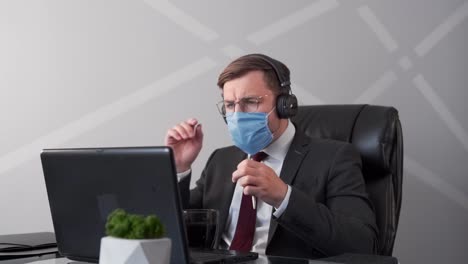 Geschäftsmann-In-Medizinischer-Maske-Und-Geschäftsanzug,-Der-über-Webcam-In-Kopfhörern-Spricht