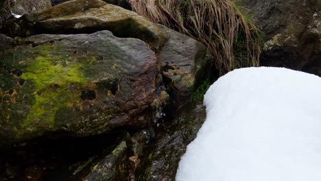 Wide-angle-of-small-water-stream-from-rock-during-winter-season,-medium-shot