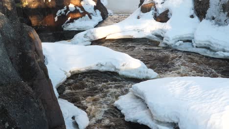 Wunderschönes,-Mäandrierendes-Flusswasser-Fließt-Um-Schneebedeckte-Landvorsprünge