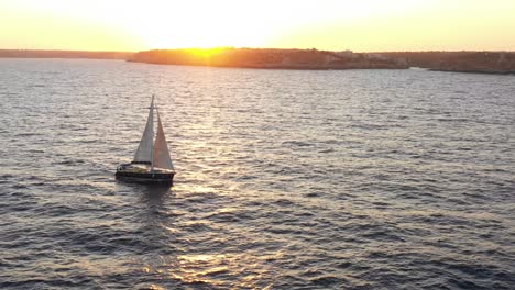 Blick-Auf-Den-Sonnenuntergang-Von-Einer-Drohne-Mit-Einem-Segelboot