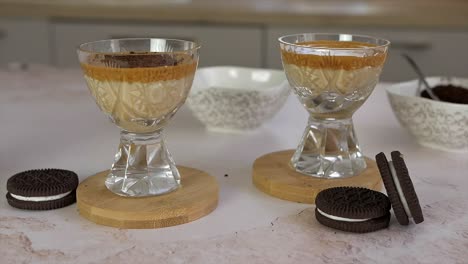 Zwei-Gläser-Köstlicher-Dalgona-Kaffee-In-Der-Küche,-Schokoladenkeksbrötchen-Hinein