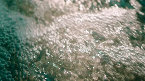 Closeup-view-of-fresh-water-stream-gushing-air-bubbles-popping