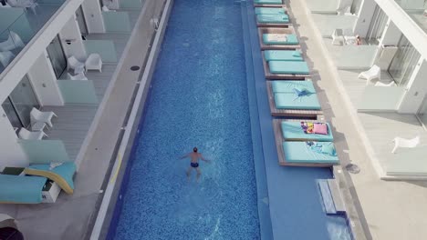 Aerial-view-of-a-man-swimming-in-the-pool,-top-view