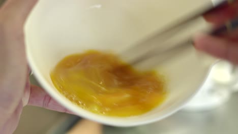 Fresh-Egg-Mixing-With-A-Pair-Of-Chopsticks-In-Tokyo,-Japan---Close-Up-Shot