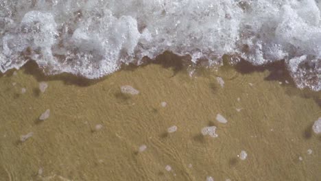 top-view-of-small-ocean-waves-going-back-and-forth---slow-motion-static-shot
