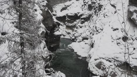 Ein-Kleiner-Fluss,-Der-Im-Winter-Durch-Die-Schneeweißen-Berge-Und-Die-Landschaft-Der-Kaskadenfälle-Fließt---Weitschuss