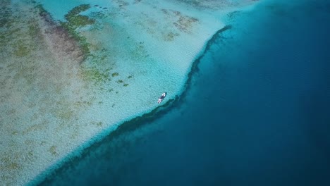 Vista-De-Drones-De-Un-Pequeño-Barco-De-Pesca,-Flotando-En-El-Mar-Caribe-Azul,-En-Los-Roques-Venezuela