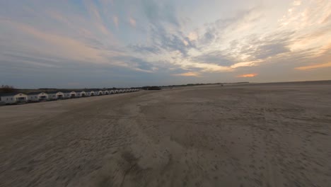 Aerial-drone-flight-through-empty-Vrouwenpolder-beach-playground-in-sunset