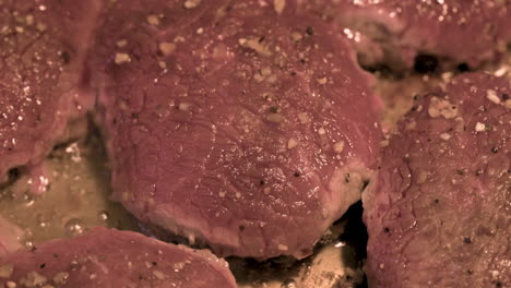 Macro-shot-of-delicious-juicy-meat-steaks-cooking-in-frying-pan