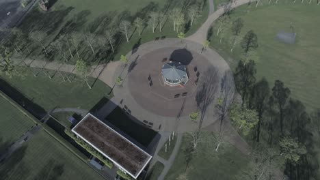 Drone-flying-over-desolate-deserted-British-park-pavilion-bandstand-during-covid-lock-down-birds-eye-tilt-up
